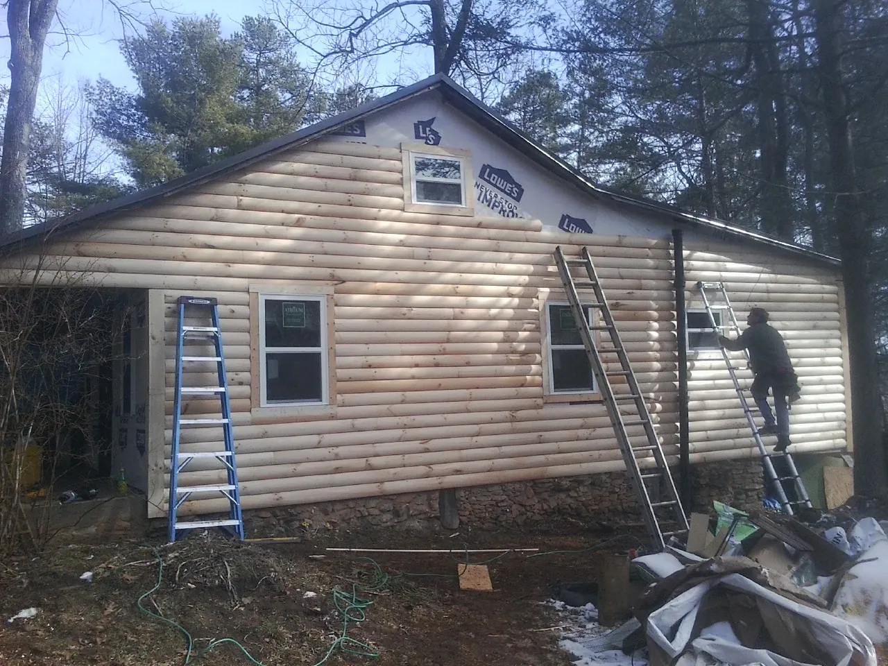 Ladders set against fresh log siding during an exterior remodel in Cedar Hill